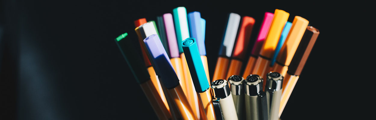 colorful pens against a black background