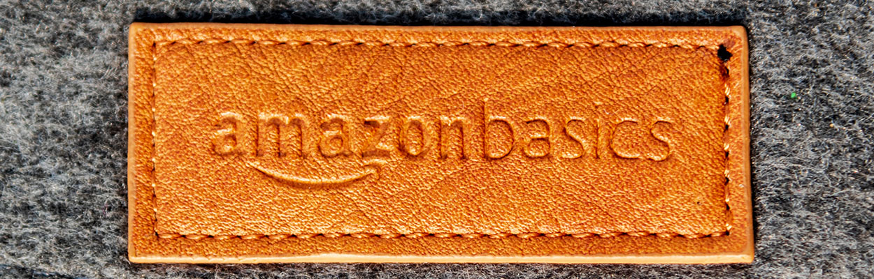 a faux leather patch bearing the amazon basics logo on a grey felt background