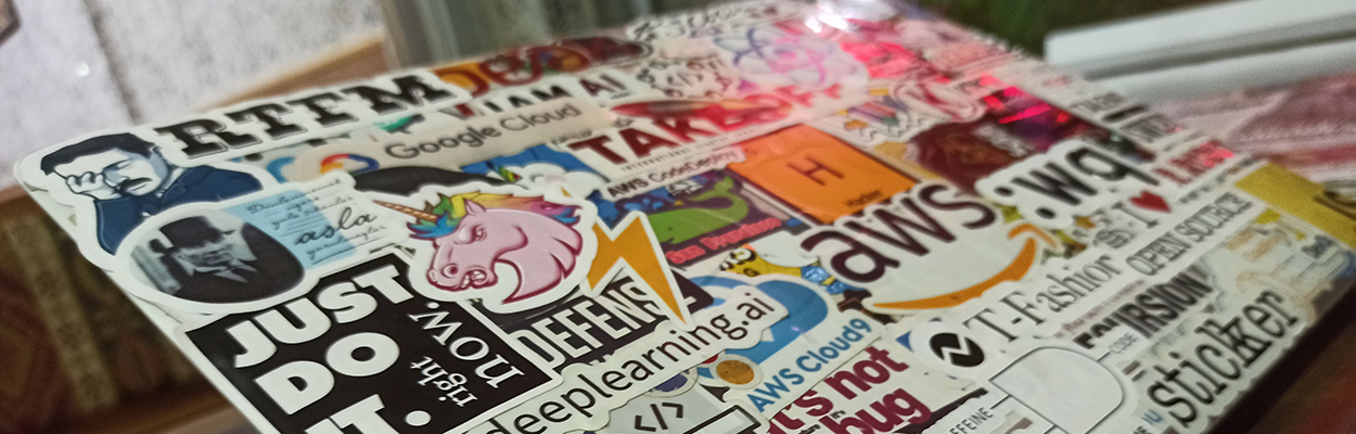 sticker-covered laptop featuring GitHub and AWS stickers